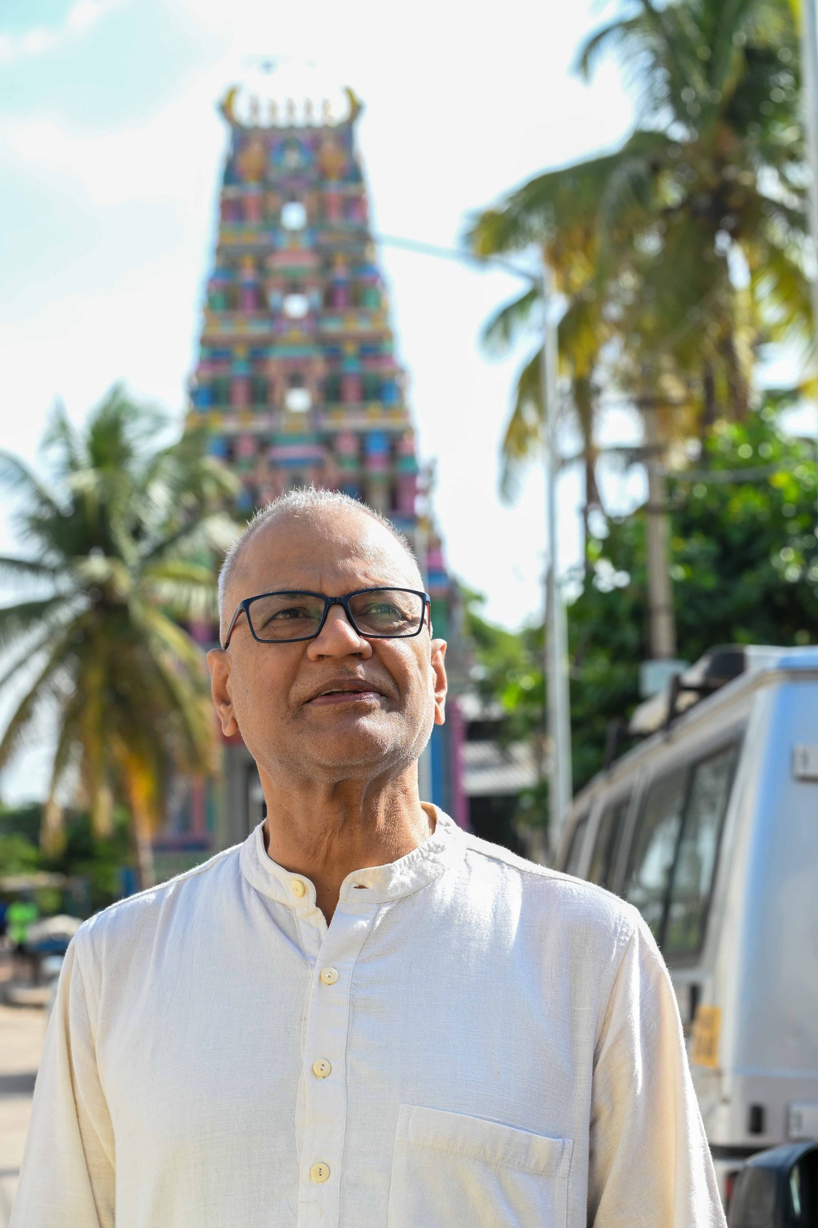 Rajesh Anand standing before a traditional temple tower