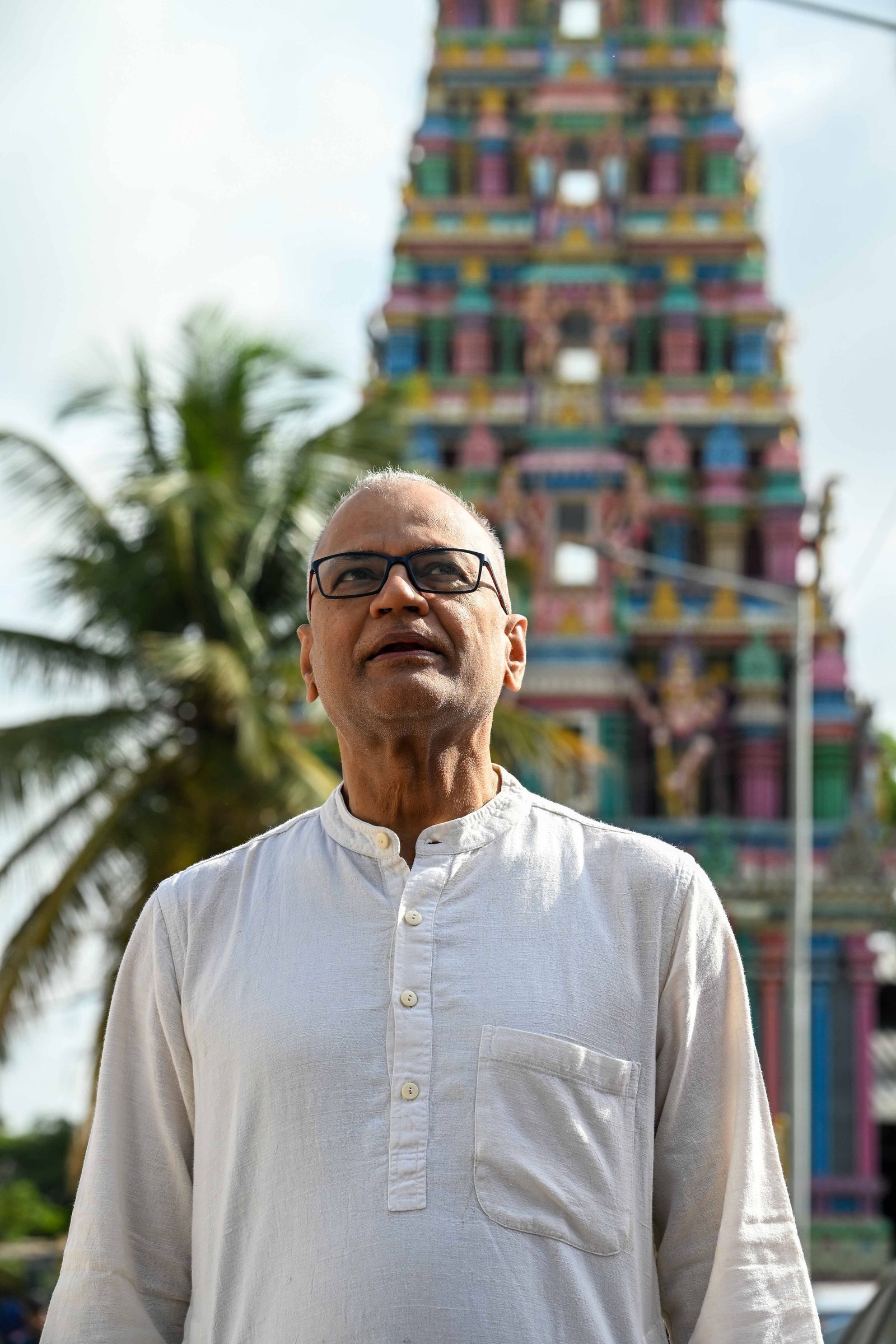 Rajesh Anand standing before a temple tower