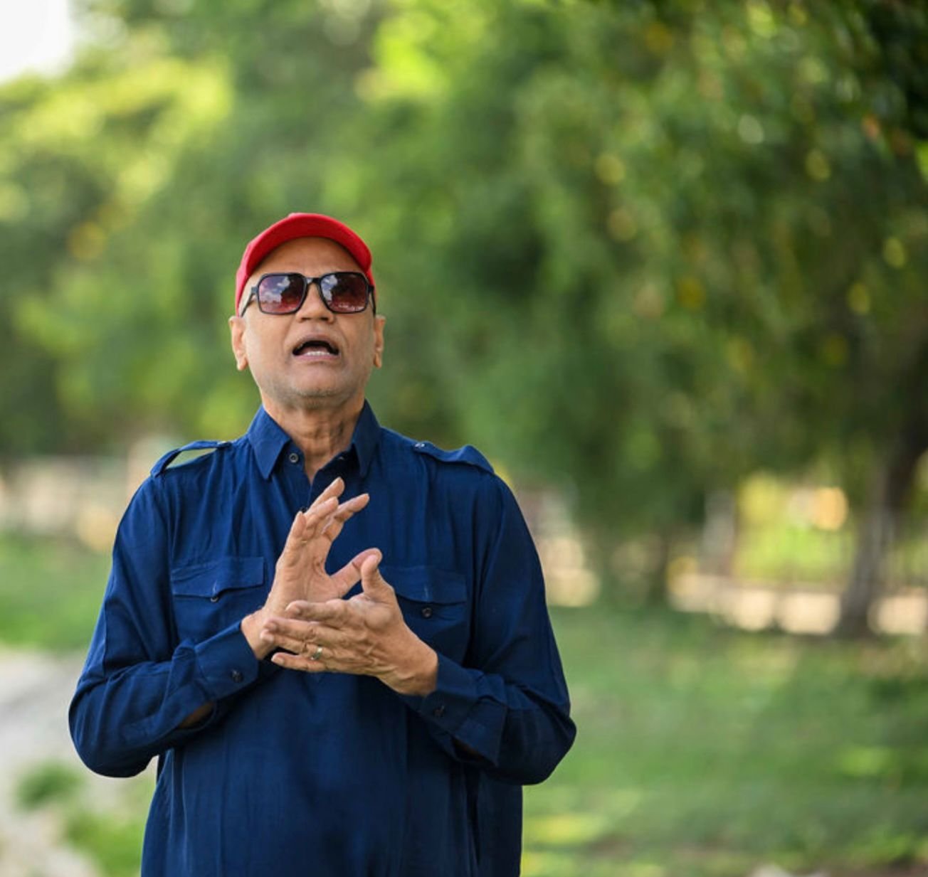 Rajesh Anand speaking outdoors in navy